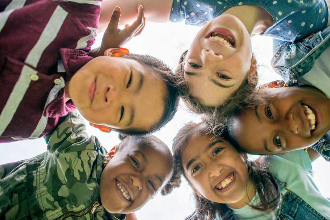 Group of Multi-ethnic school aged children gathering outside together